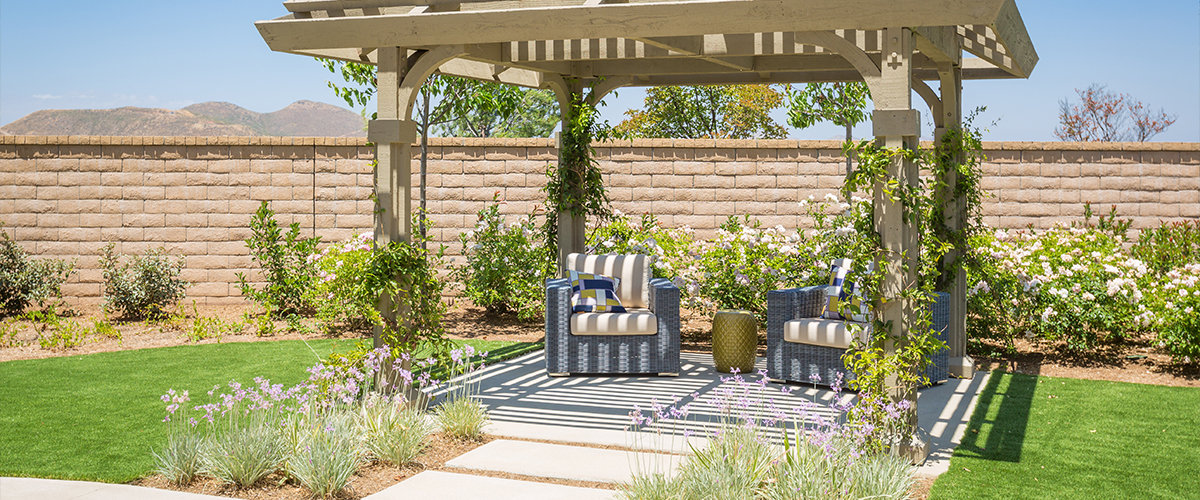 Pergola with two chairs underneath.